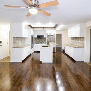 kitchen featuring white cabinetry, appliances with stainless steel finishes, a center island with sink, and backsplash