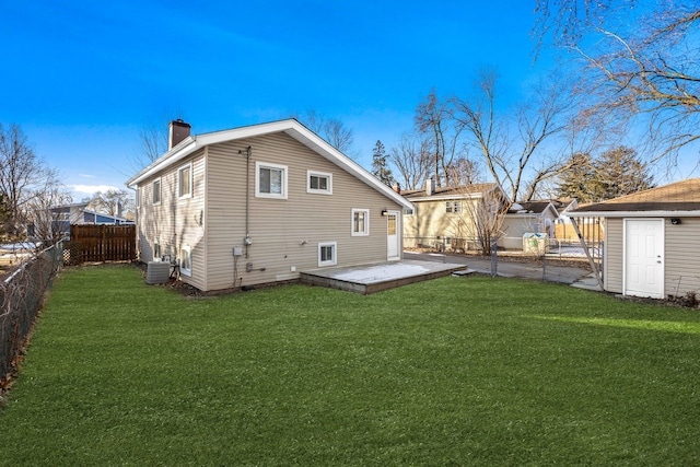 rear view of house with a patio, an outdoor structure, a yard, and central AC unit