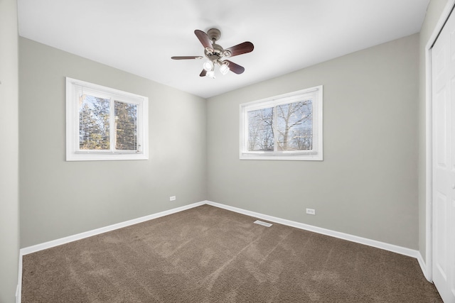 carpeted spare room featuring ceiling fan