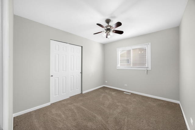 unfurnished bedroom with ceiling fan, carpet floors, and a closet