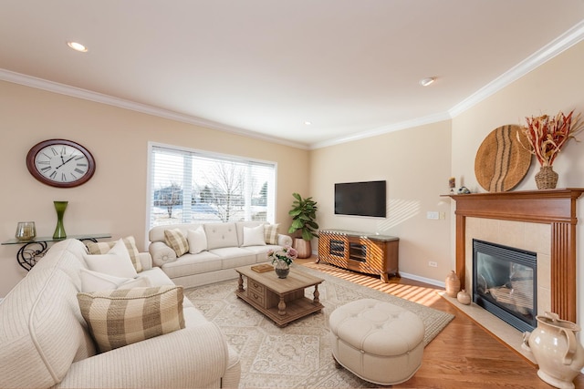 living room with a tile fireplace, crown molding, and light hardwood / wood-style flooring