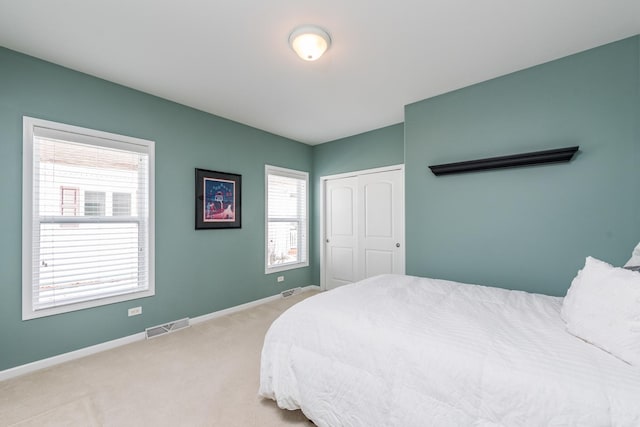 bedroom featuring light colored carpet and a closet