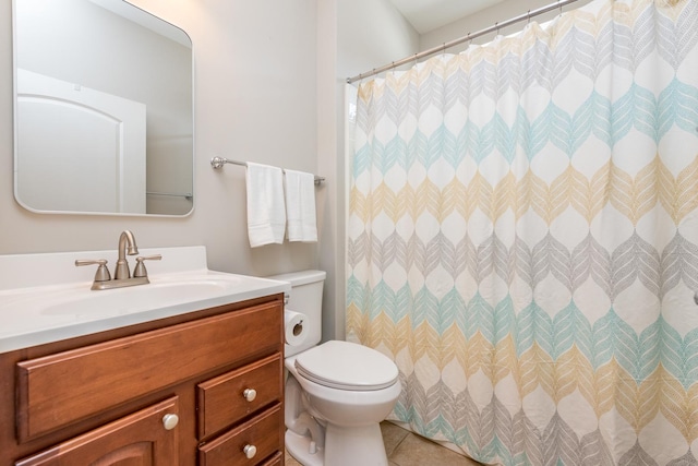 bathroom with tile patterned flooring, vanity, and toilet