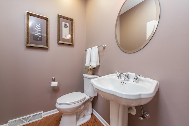 bathroom featuring wood-type flooring, sink, and toilet