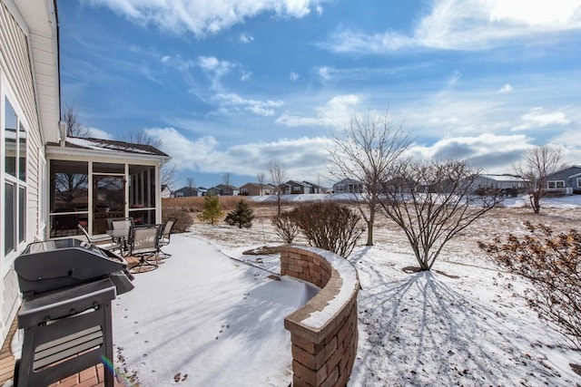 snow covered deck featuring a sunroom