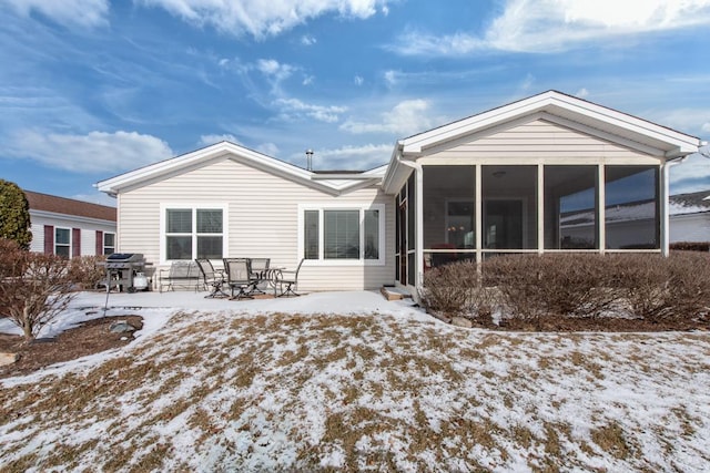 snow covered property with a sunroom