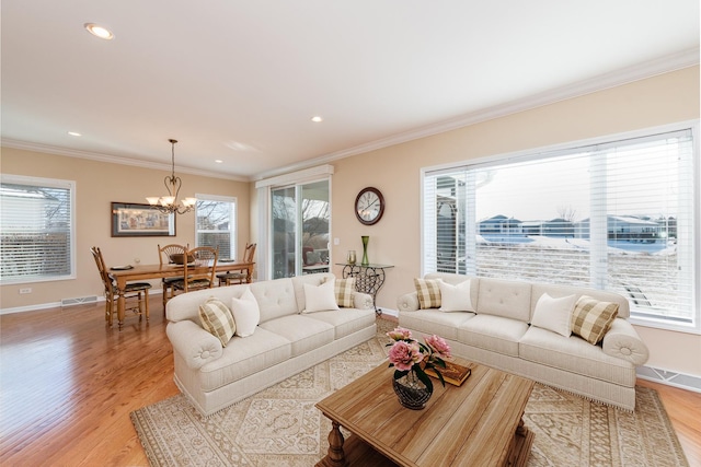 living room featuring ornamental molding, light hardwood / wood-style floors, and a healthy amount of sunlight