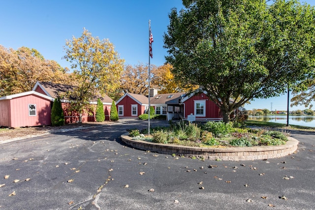 single story home featuring a water view and a storage shed