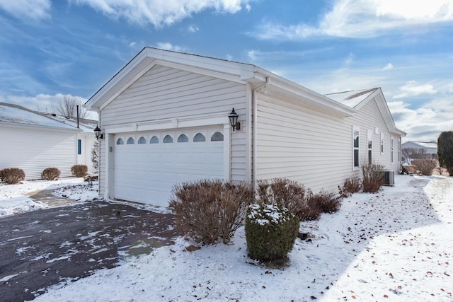 view of snow covered exterior featuring a garage