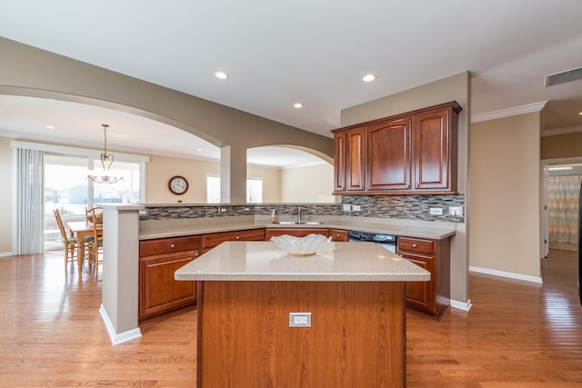 kitchen featuring dishwasher, a kitchen island, pendant lighting, and kitchen peninsula