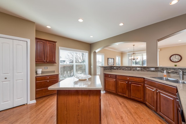 kitchen featuring pendant lighting, light hardwood / wood-style floors, sink, and a kitchen island