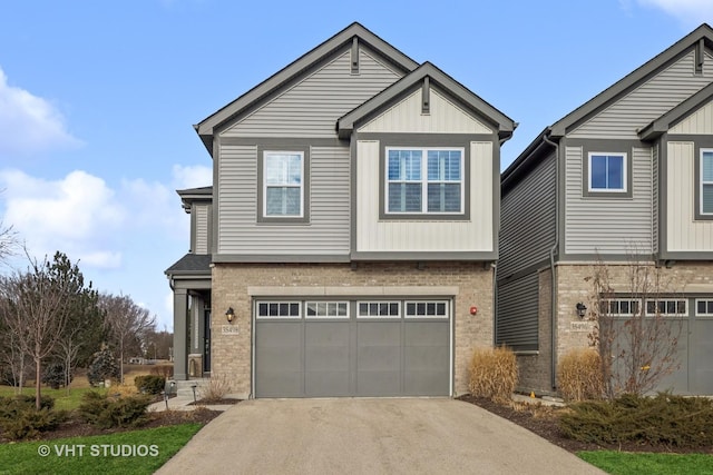 view of front of home featuring a garage, driveway, brick siding, and board and batten siding