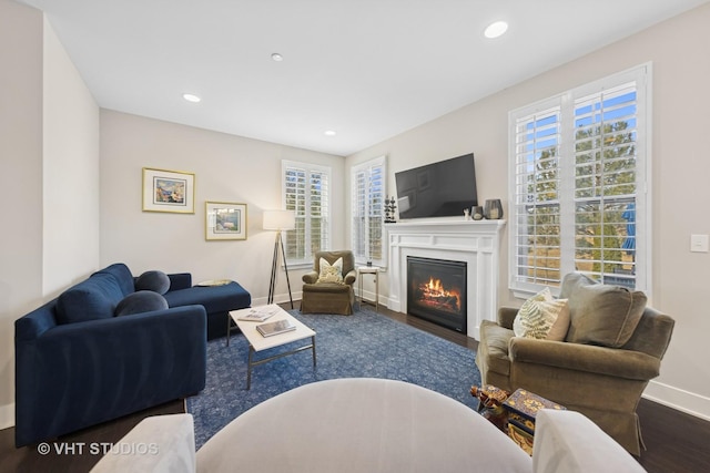 living room with recessed lighting, baseboards, wood finished floors, and a glass covered fireplace