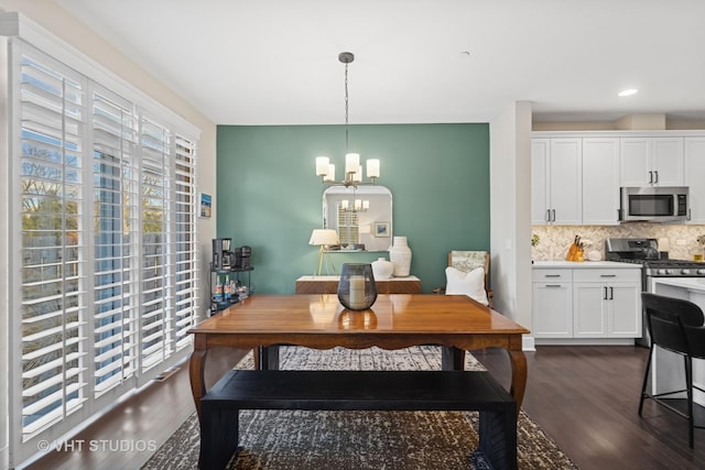 dining area featuring dark wood-style flooring, recessed lighting, and an inviting chandelier