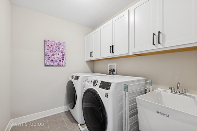 laundry room featuring light tile patterned floors, washing machine and dryer, a sink, baseboards, and cabinet space