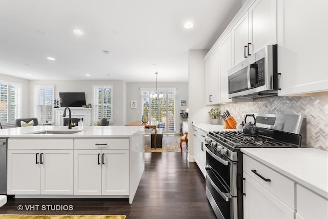 kitchen with appliances with stainless steel finishes, light countertops, and a sink