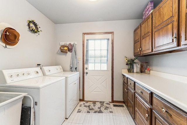 washroom featuring cabinets, sink, light tile patterned floors, and independent washer and dryer