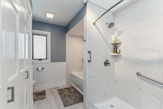 bathroom featuring toilet and tiled shower