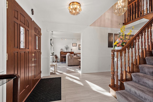 foyer with rail lighting and a chandelier