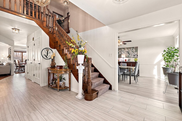 staircase featuring ceiling fan