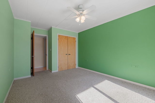 unfurnished bedroom featuring crown molding, a closet, ceiling fan, and carpet flooring