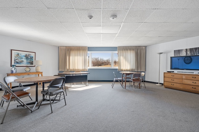 carpeted dining space featuring a paneled ceiling