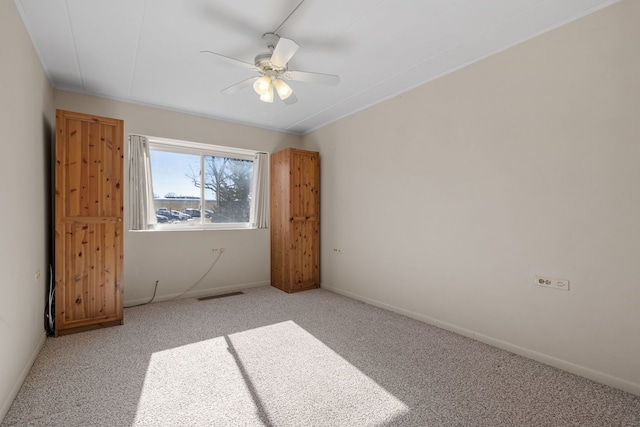 carpeted spare room featuring ceiling fan