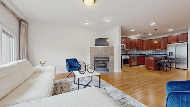 living room with light hardwood / wood-style floors and a tile fireplace