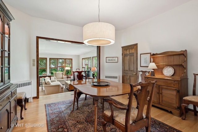 dining area featuring radiator heating unit and light hardwood / wood-style floors