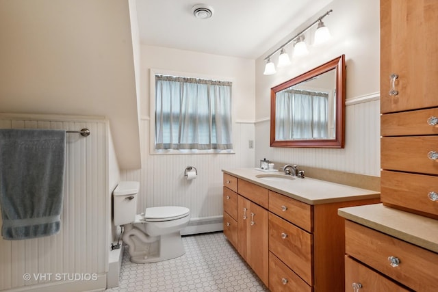 bathroom featuring vanity, a baseboard heating unit, and toilet