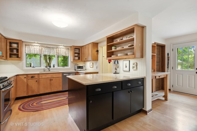 kitchen featuring stainless steel appliances, sink, a wealth of natural light, and light hardwood / wood-style flooring