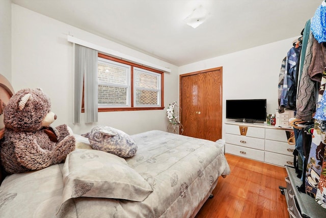 bedroom with light hardwood / wood-style floors and a closet