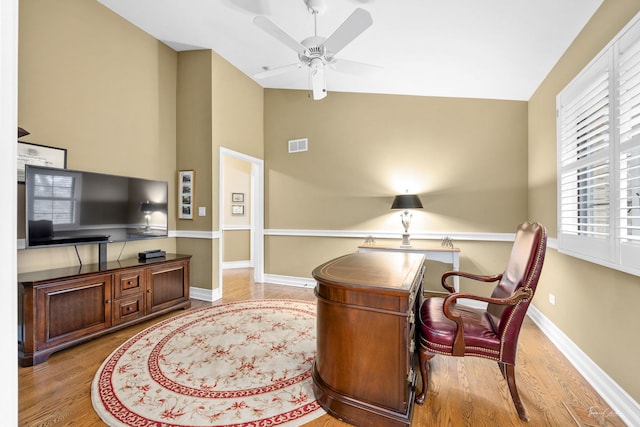 living area with lofted ceiling, light hardwood / wood-style flooring, and ceiling fan