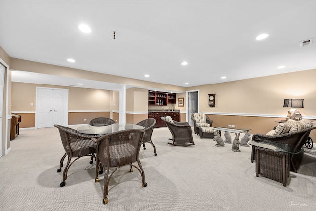 dining room featuring bar and light carpet