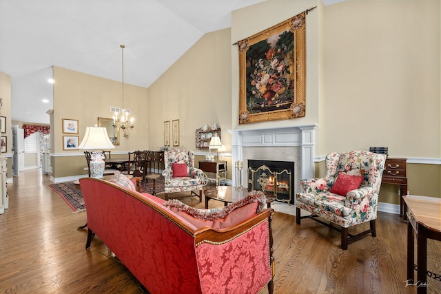 living room with hardwood / wood-style flooring, high vaulted ceiling, and a notable chandelier