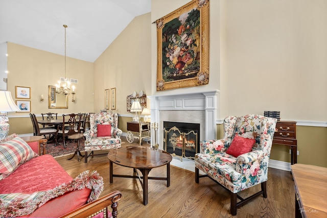 living room featuring high vaulted ceiling, hardwood / wood-style floors, and a notable chandelier