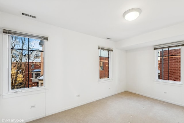 unfurnished room featuring carpet and a wealth of natural light