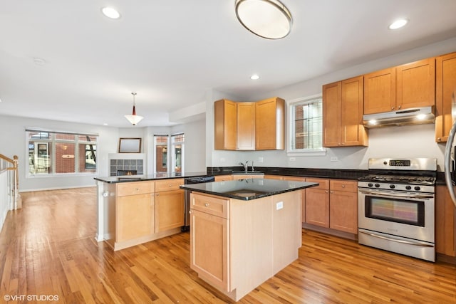 kitchen featuring sink, hanging light fixtures, light hardwood / wood-style floors, kitchen peninsula, and stainless steel appliances