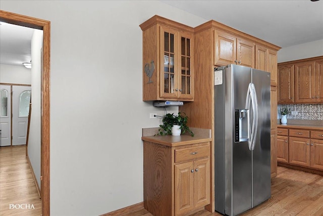 kitchen featuring tasteful backsplash, stainless steel fridge, and light wood-type flooring