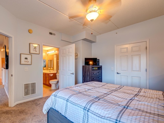 bedroom featuring light carpet, baseboards, visible vents, and ensuite bathroom