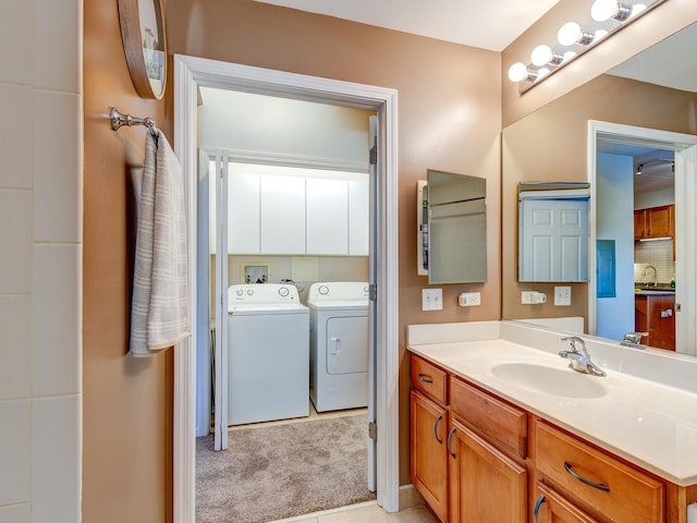 bathroom with independent washer and dryer and vanity