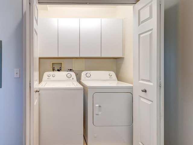 laundry room featuring washing machine and clothes dryer and cabinet space