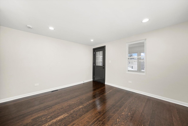 spare room featuring dark wood-type flooring