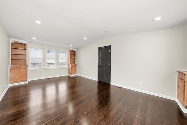 unfurnished living room featuring dark hardwood / wood-style flooring, built in shelves, and lofted ceiling