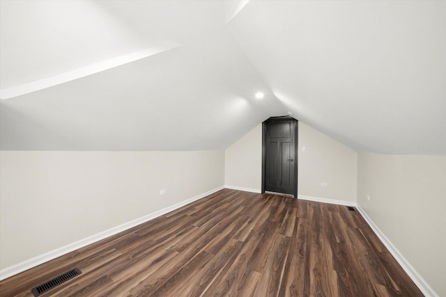 additional living space with vaulted ceiling and dark hardwood / wood-style floors