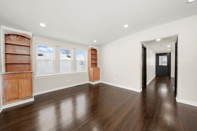 unfurnished living room with dark wood-type flooring