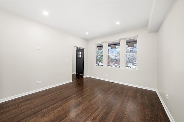 unfurnished room with dark wood-type flooring