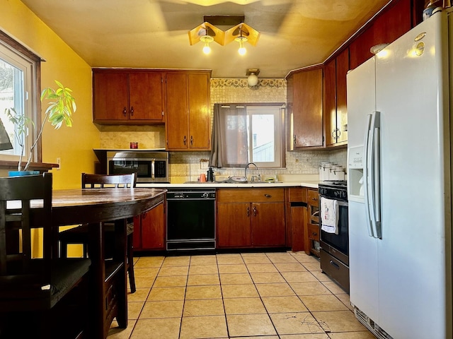 kitchen with plenty of natural light, white refrigerator with ice dispenser, sink, and dishwasher