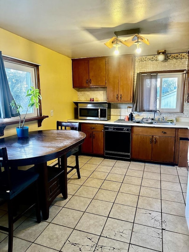 kitchen featuring plenty of natural light, dishwasher, sink, and light tile patterned floors