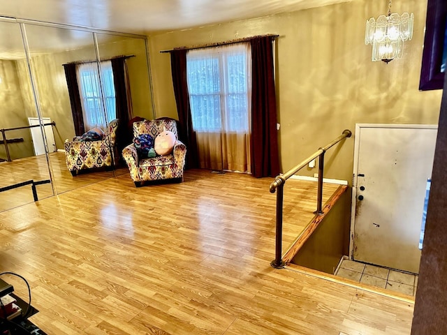 living area with hardwood / wood-style floors, a notable chandelier, and plenty of natural light